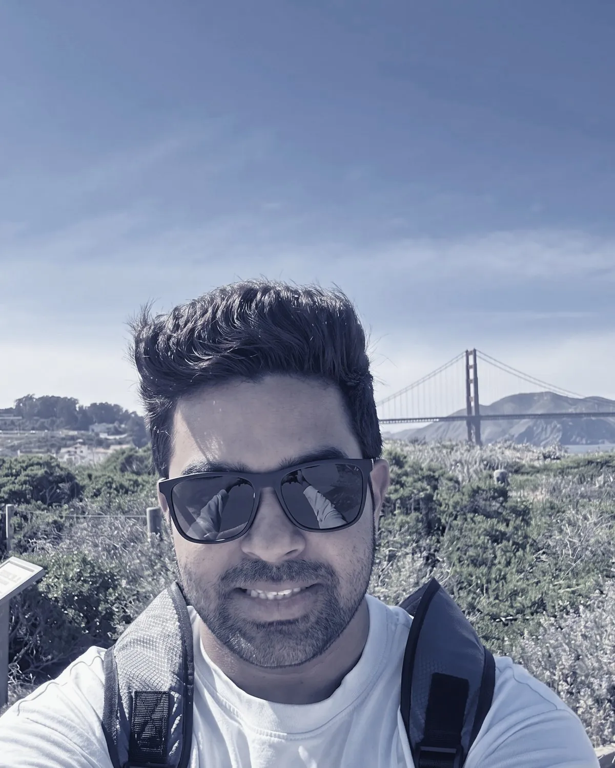 Deb Mukherjee in sunglasses, with the Golden Gate Bridge behind him